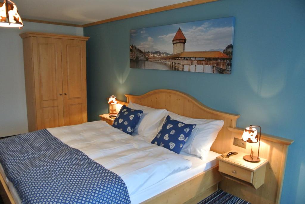ein Schlafzimmer mit einem Bett und einem Bild an der Wand in der Unterkunft Gasthaus Tübli Gersau in Gersau