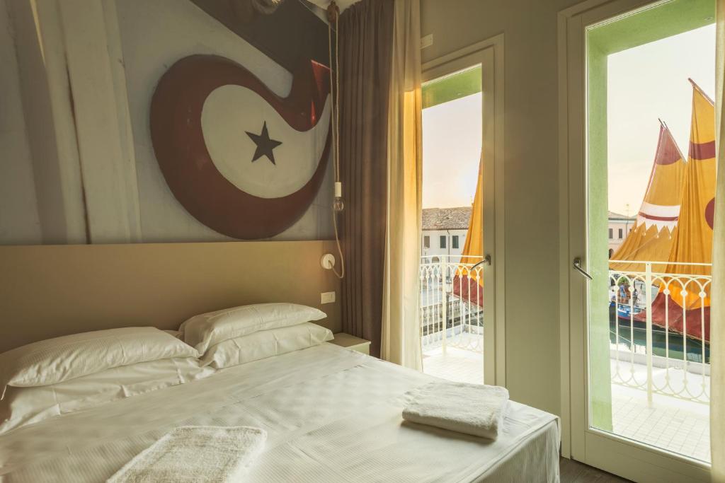 a bedroom with a bed and a view of a balcony at porto canale b & b in Cesenatico