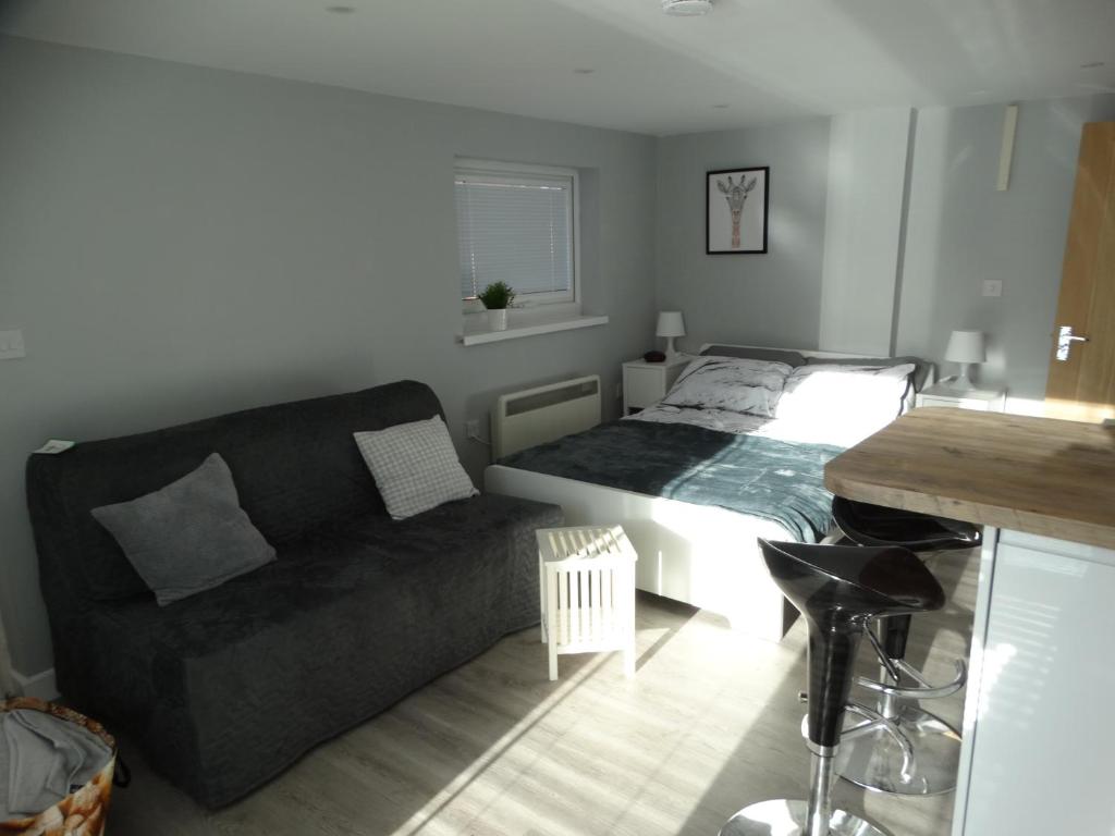 uma sala de estar com uma cama e um sofá em The Annexe em Preston