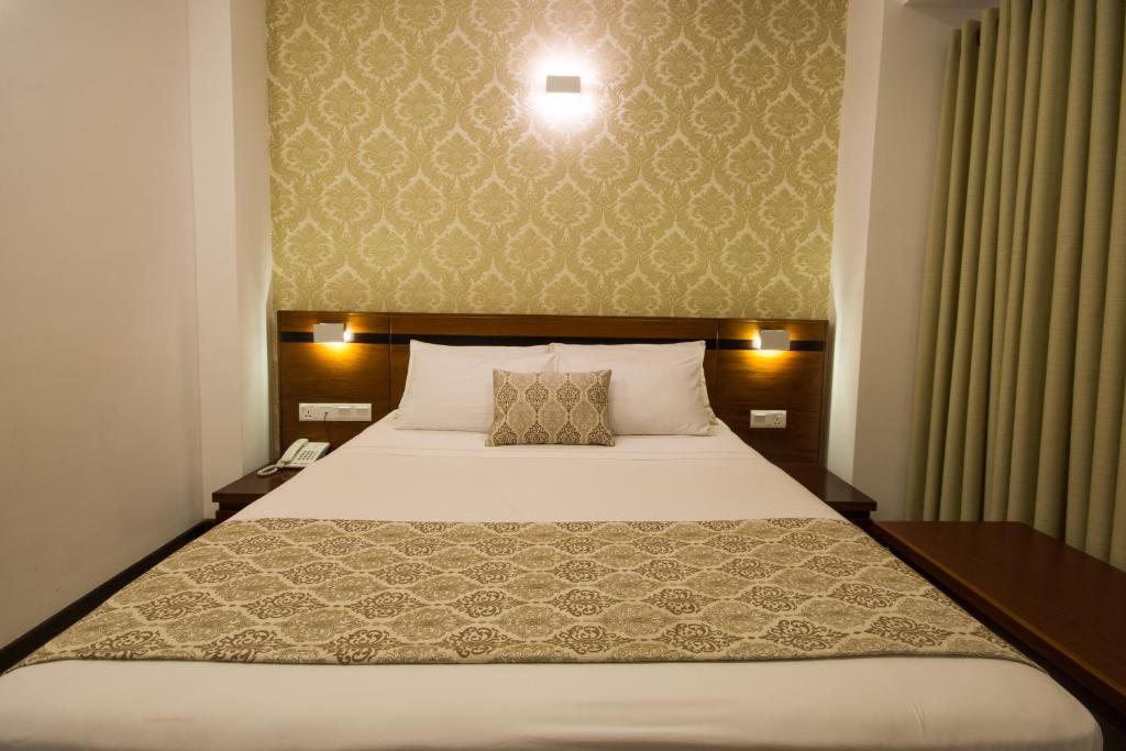 Postel nebo postele na pokoji v ubytování Ceyloni City Hotel