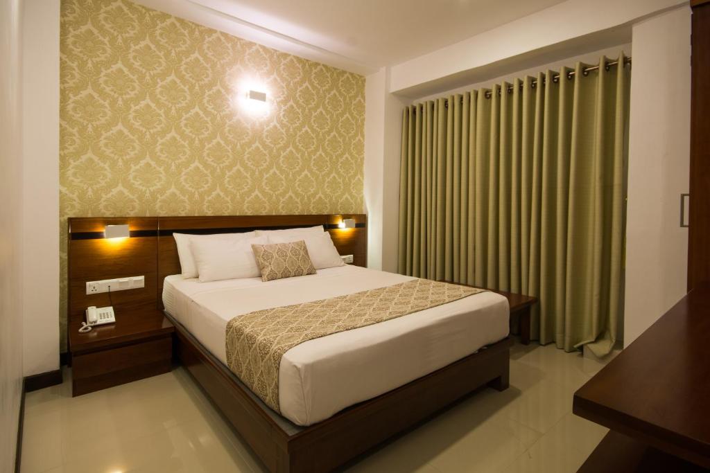 Postel nebo postele na pokoji v ubytování Ceyloni City Hotel