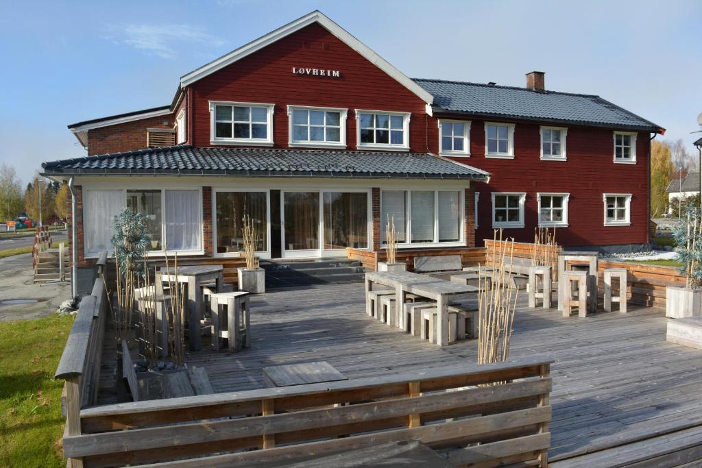 una casa con una terraza de madera frente a ella en Løvheim Gjestehus - Anneks en Sauland