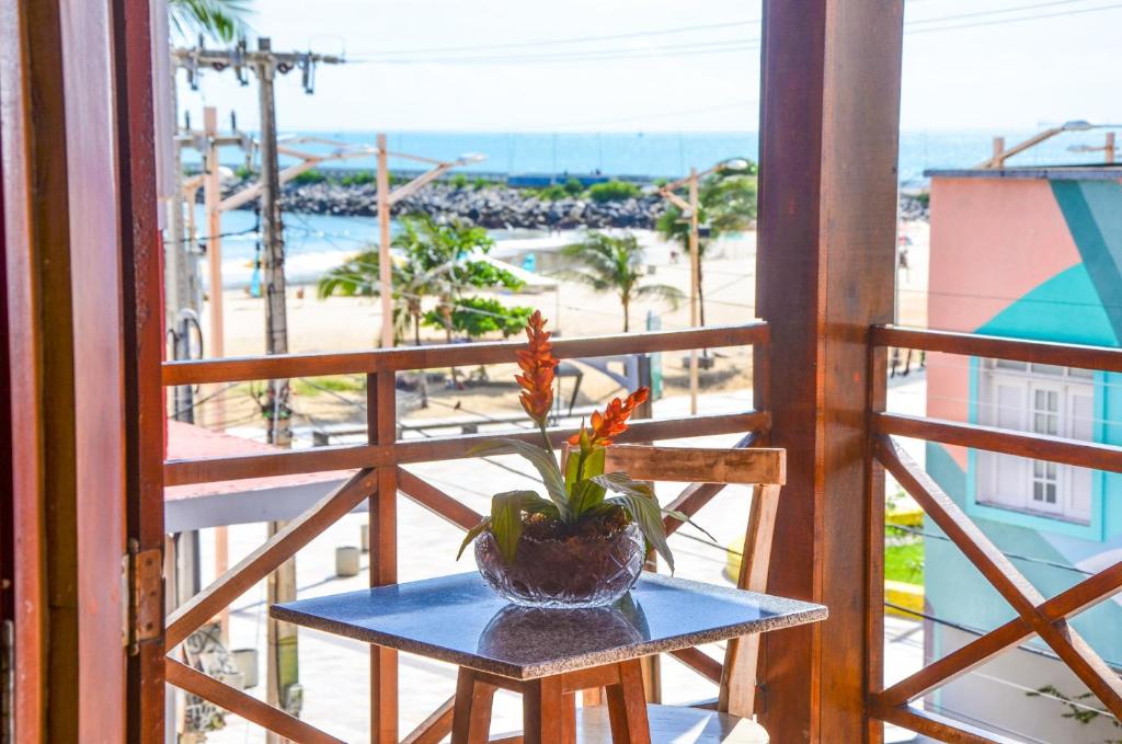 a table with a plant on a balcony with a beach at Pousada Fortal Villa Praia in Fortaleza