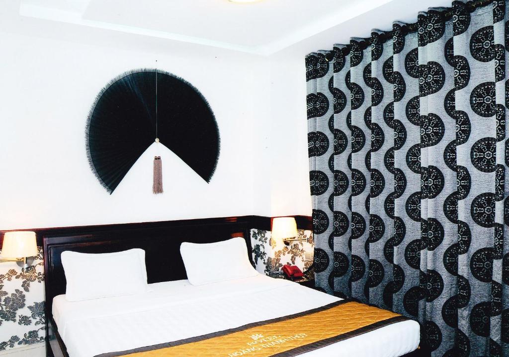 ein Schlafzimmer mit einem Bett und einer schwarz-weißen Wand in der Unterkunft Hoang Thanh Thuy Hotel 2 in Ho-Chi-Minh-Stadt