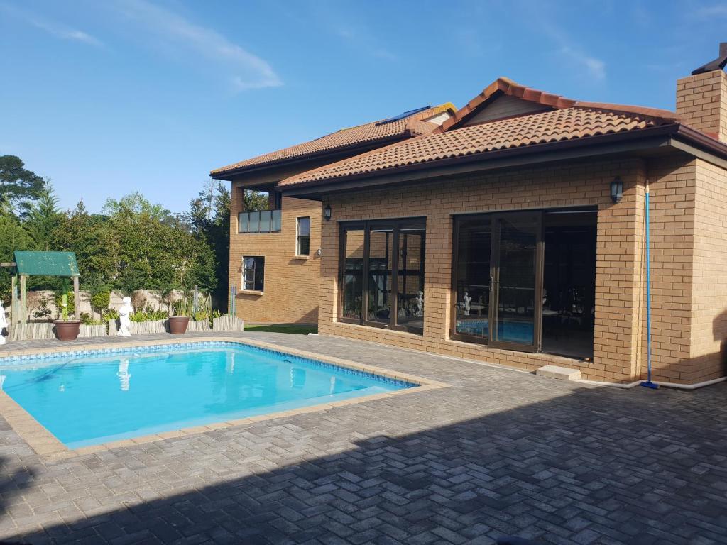 a swimming pool in front of a house at Camello in George