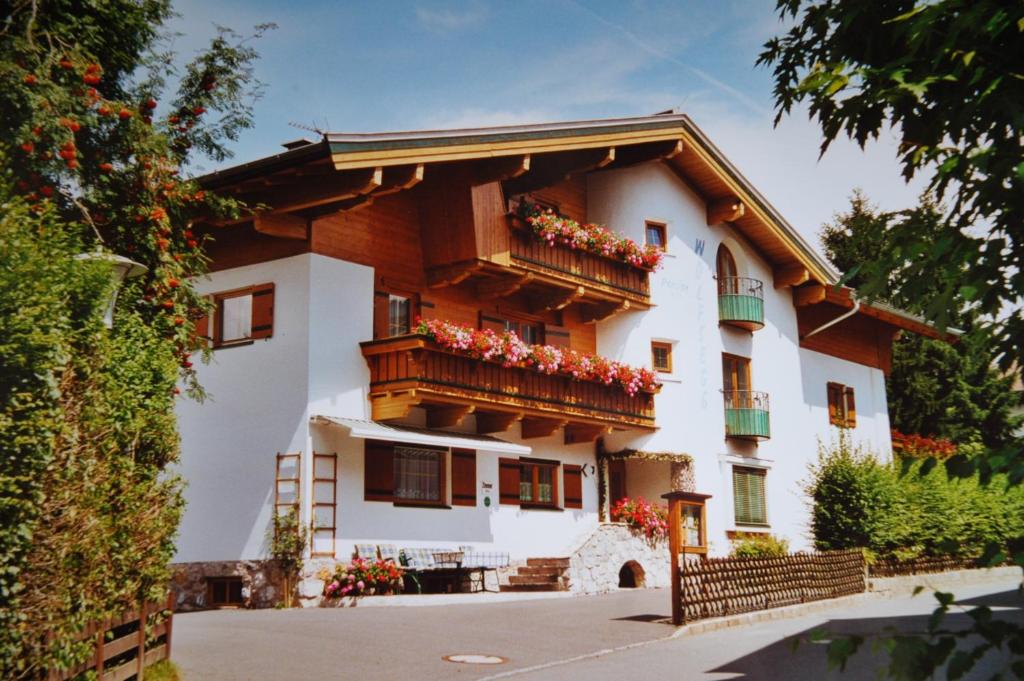 a building with flower boxes on the balconies at Pension Wolfsegg in Kirchberg in Tirol