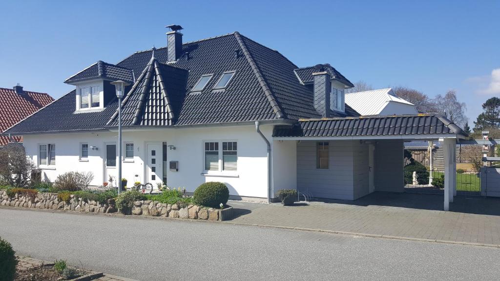 a white house with a black roof at Ferienwohnung Seeblick in Glücksburg