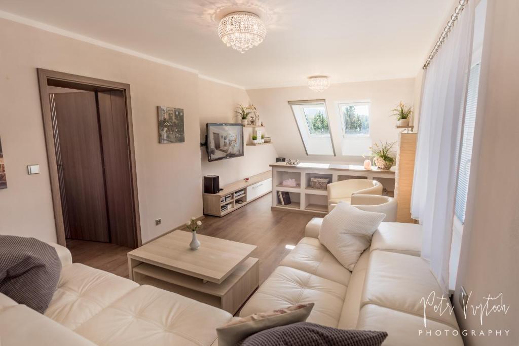 a living room with a white couch and a table at Apartmán na Lipně in Frymburk