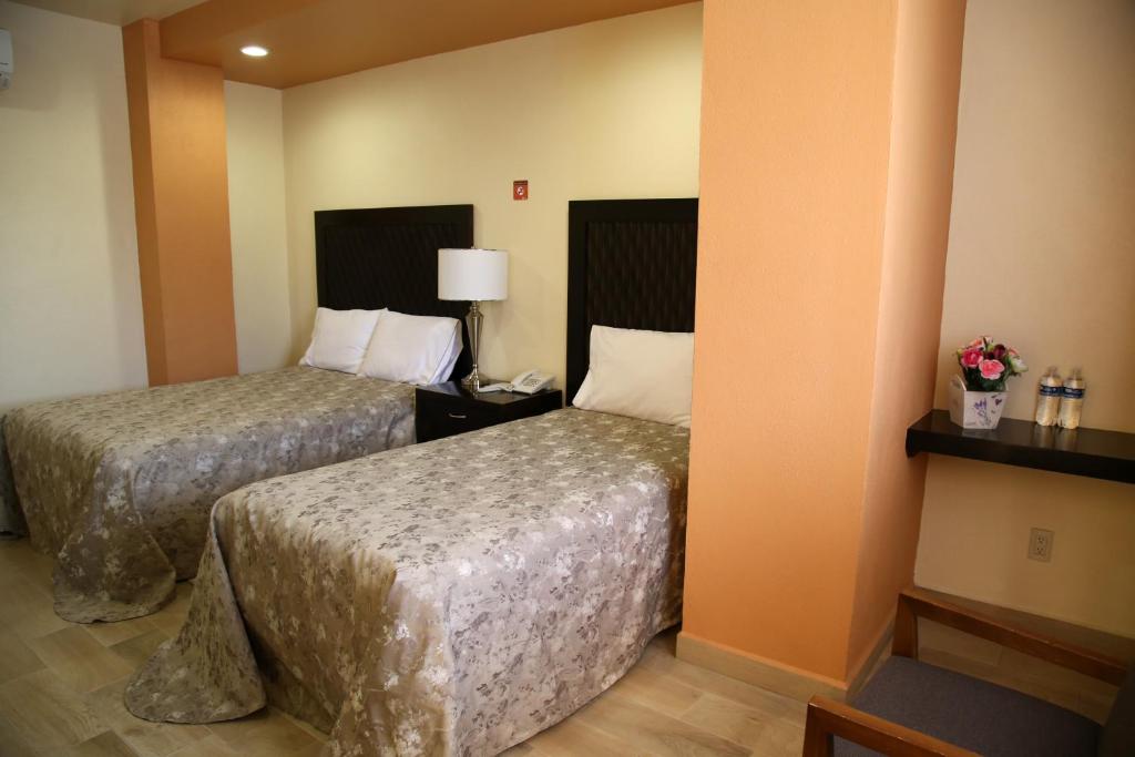 Postel nebo postele na pokoji v ubytování Hotel Plaza Bernal