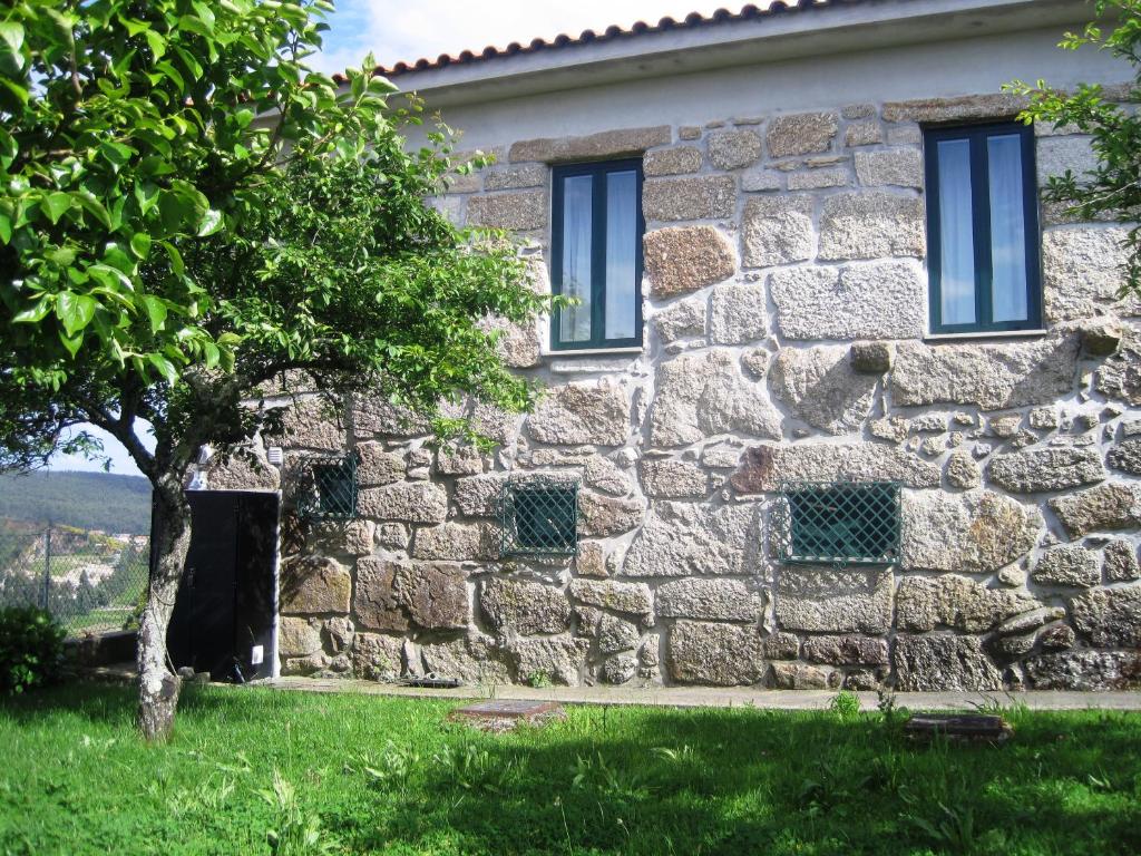 een stenen huis met een boom ervoor bij Casa dos Bisavós- Slow Down na rota do Românico in Porto