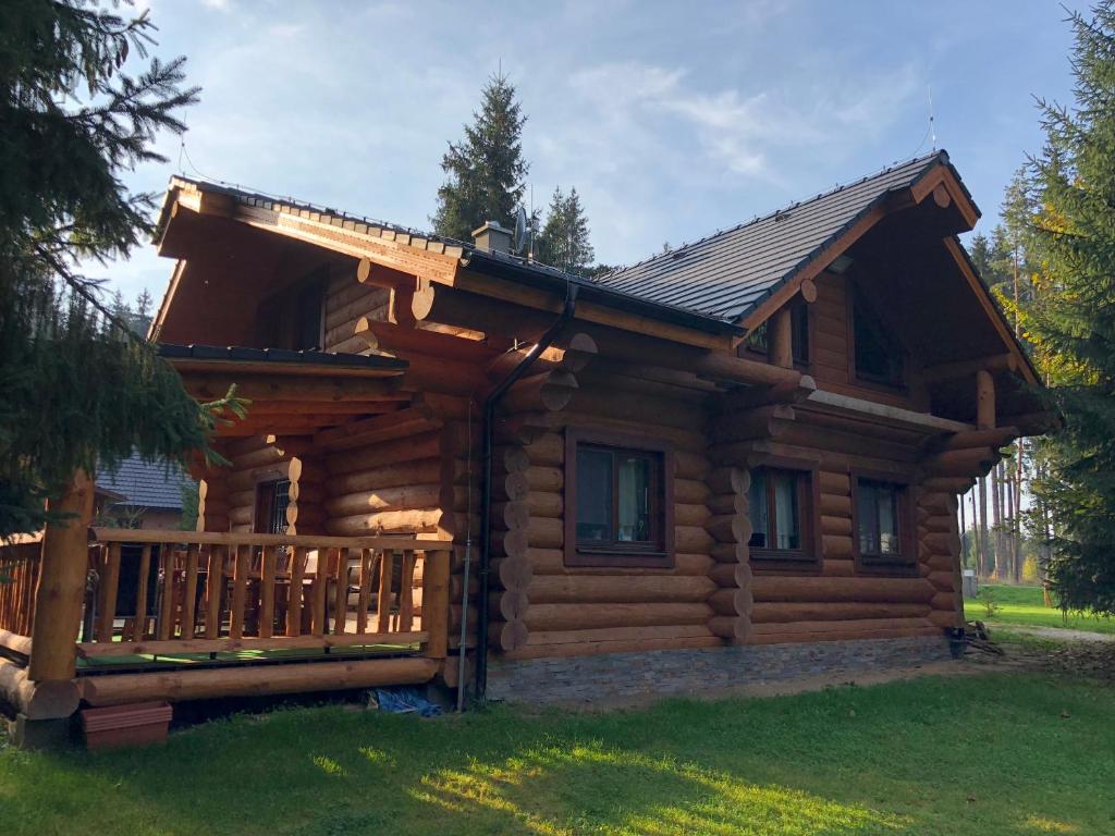 a log cabin with a porch and a deck at Luxusný zrub in Lazisko