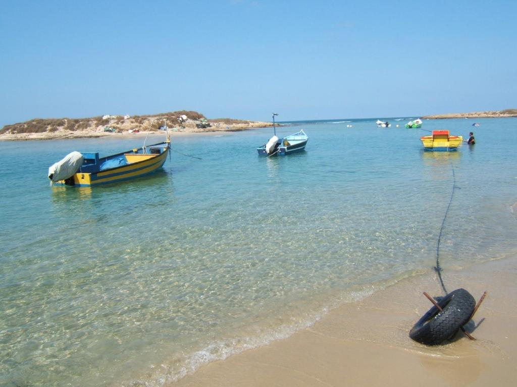 a group of boats in the water on the beach at Halom Be'Dor in Dor