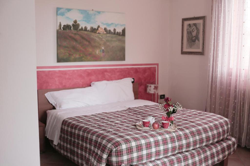 1 dormitorio con 1 cama con manta a cuadros en B&B Il Guado, en Voghenza