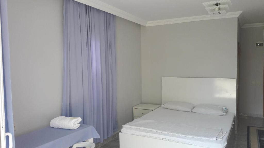 a white room with a bed and a mirror at Gunay Pansiyon Antalya in Antalya