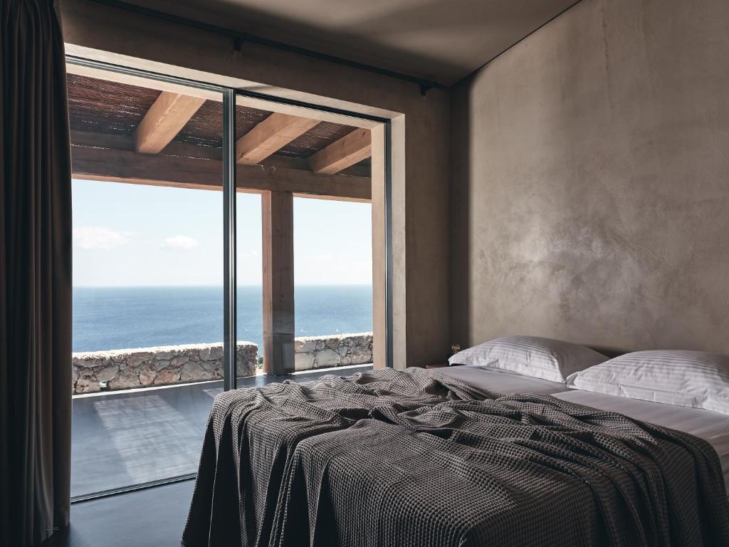 a bedroom with a bed with a view of the ocean at Vais Luxury Villas in Agios Nikolaos