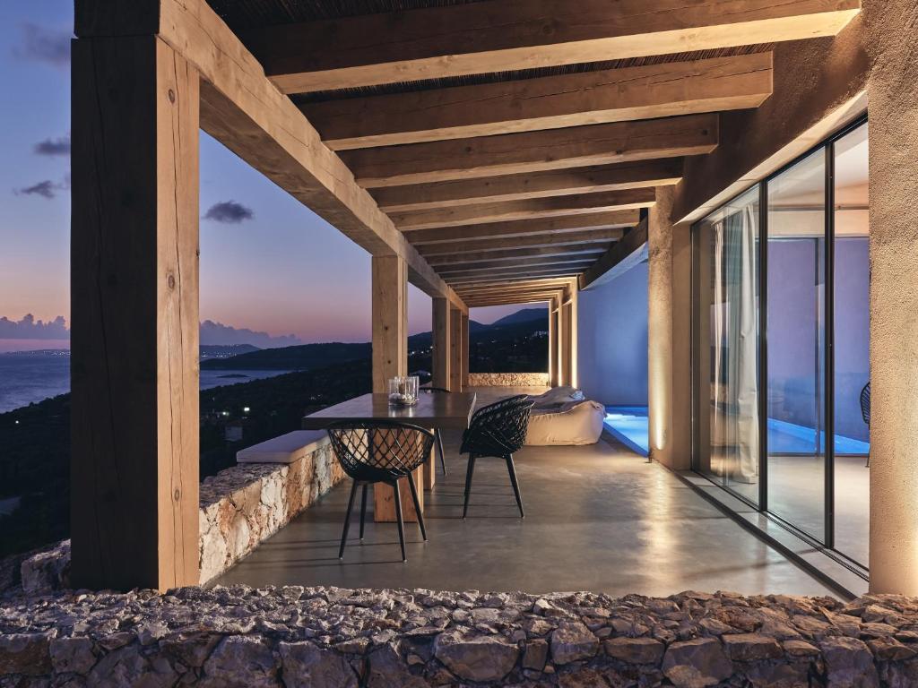 a balcony of a house with a table and chairs at Vais Luxury Villas in Agios Nikolaos