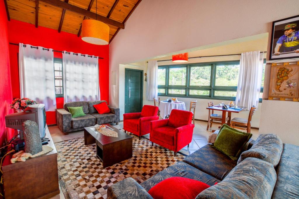 a living room with red walls and couches at Maison Bleue Suites in Monte Verde