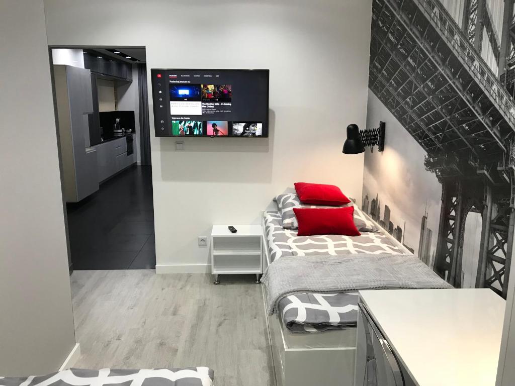 a room with a bed and a tv on the wall at Luxury Apartment - 3 lakes in Katowice