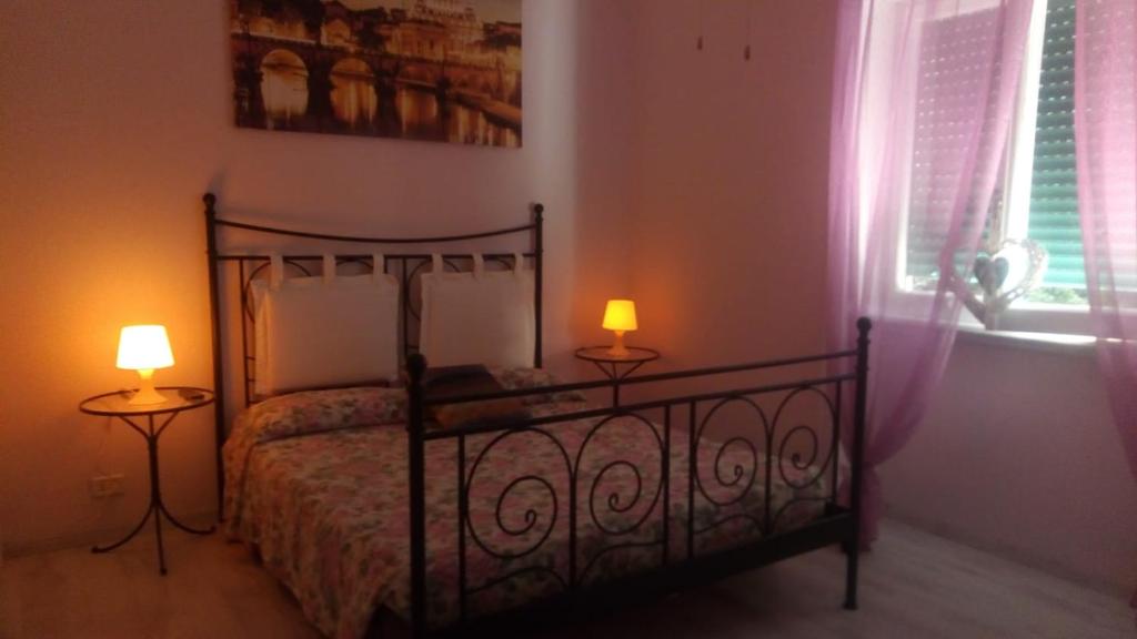 - une chambre avec un lit, deux lampes et une fenêtre dans l'établissement roma capoccia b&b, à Rome