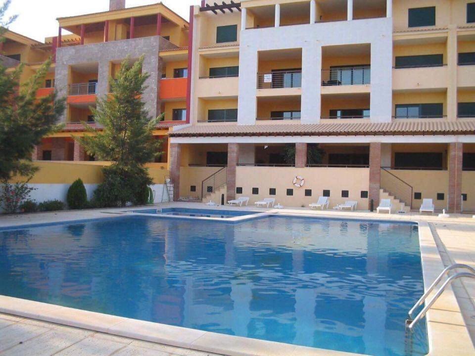 ein Schwimmbad vor einem Gebäude in der Unterkunft Apartamento golf-mar in Vilamoura