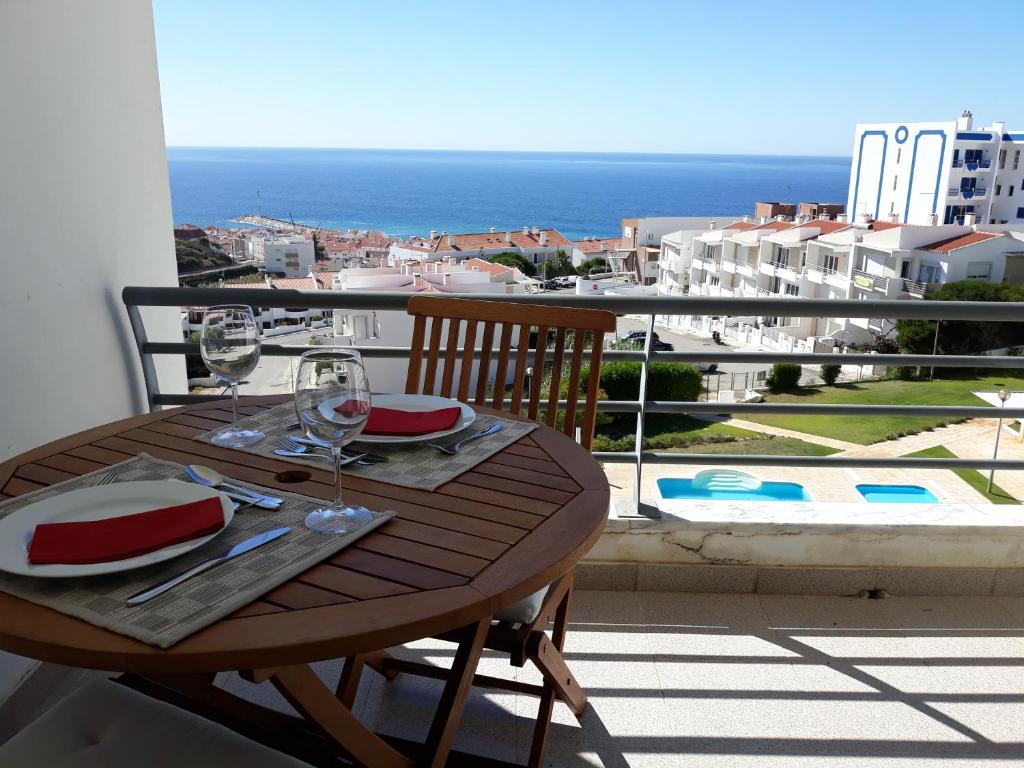 a table on a balcony with a view of the ocean at See to Sea in Ericeira