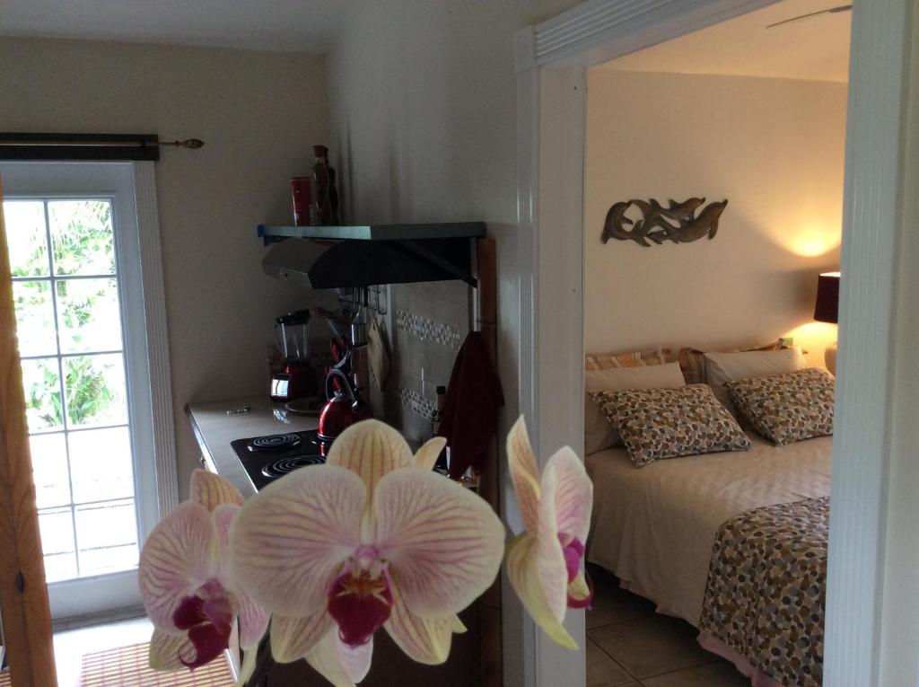 ein Schlafzimmer mit einem Bett und ein Schlafzimmer mit einer Blume in der Unterkunft Mediteranean style Ohana Rental / Garden Bungalow in Pahoa in Honolulu Landing