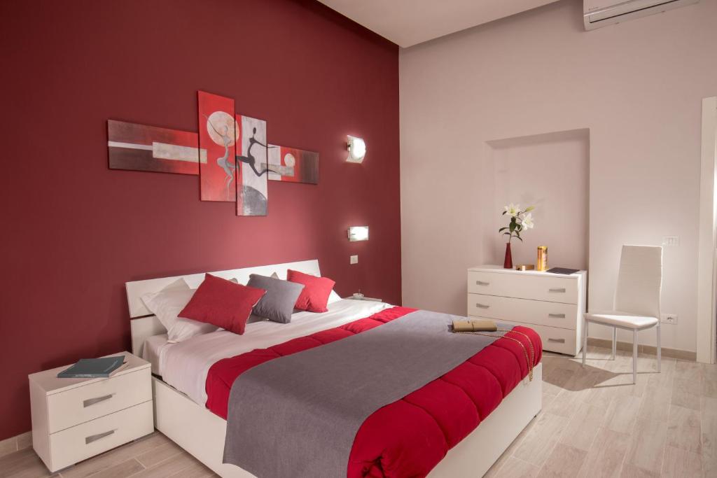- une chambre avec un grand lit aux murs rouges dans l'établissement Well Done Montebello, à Rome