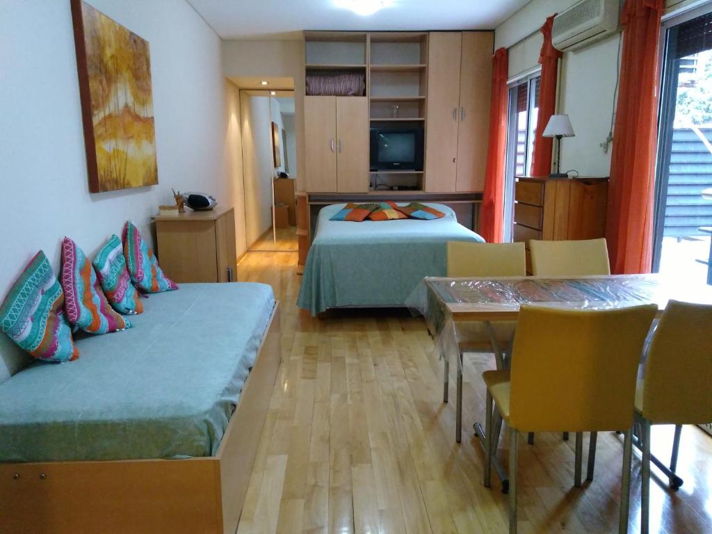 1 dormitorio con 1 cama, mesa y sillas en Malabia Botanico en Buenos Aires