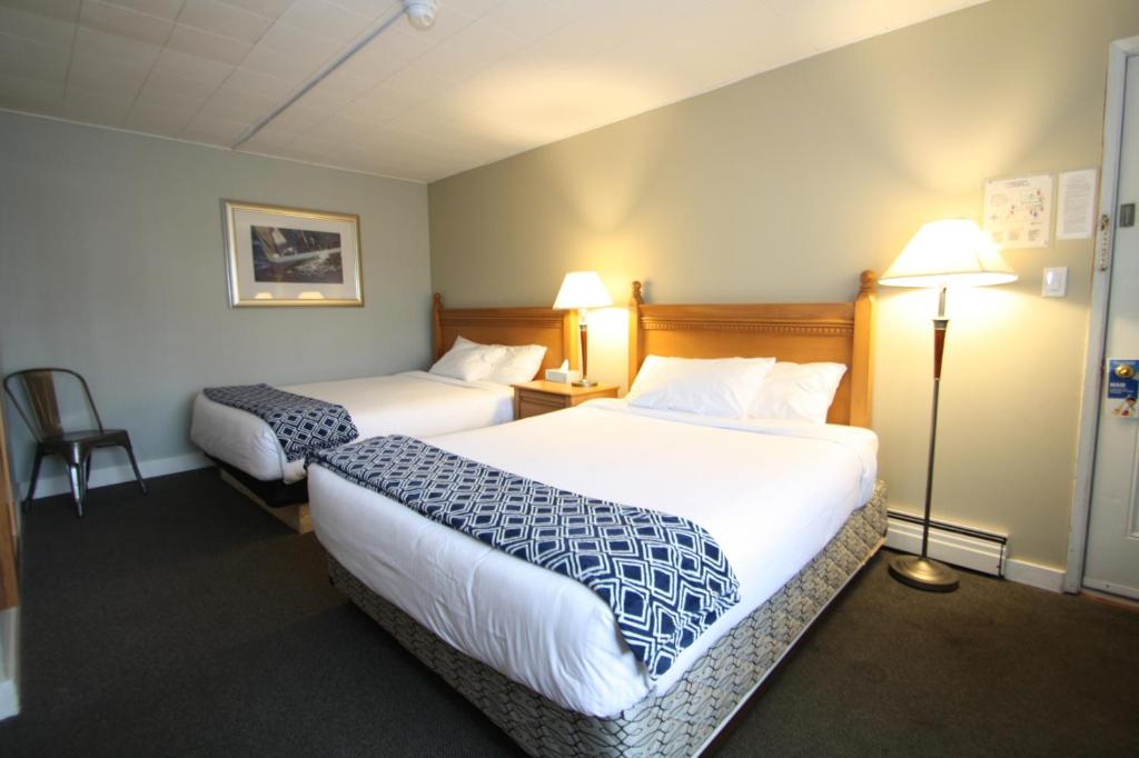 a hotel room with two beds and two lamps at Harrison Spa Motel in Harrison Hot Springs