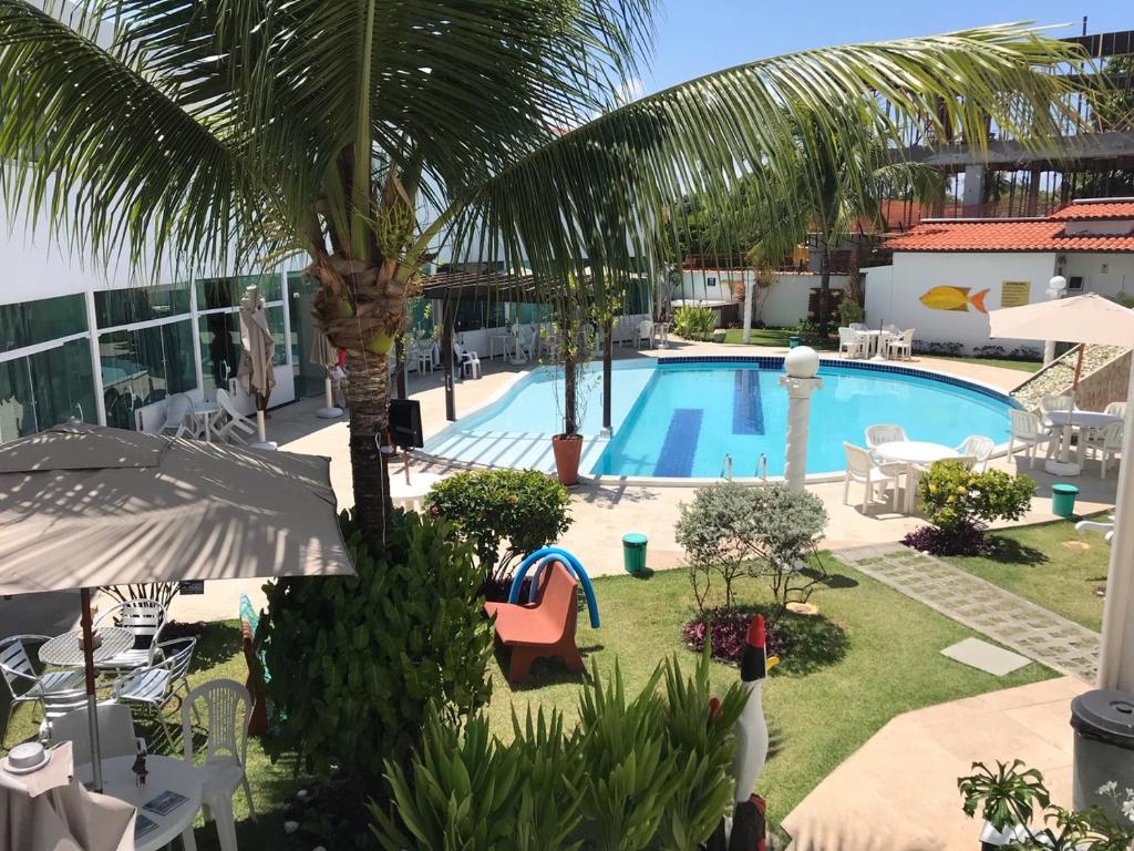 uitzicht op het zwembad vanaf het balkon van een hotel bij Residencial Madakaru - Chalé 14 in Porto De Galinhas