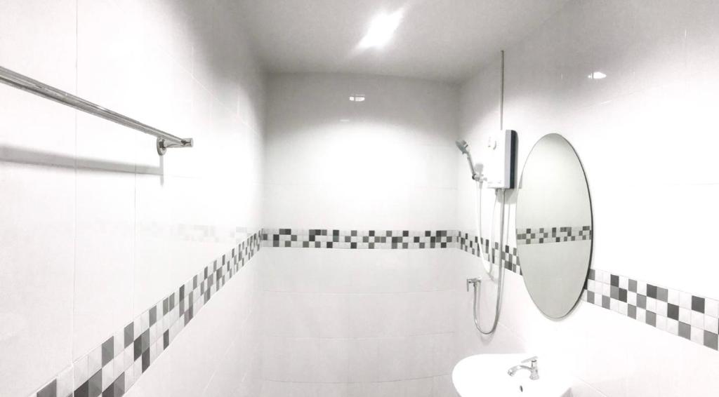 a white bathroom with a sink and a mirror at Rest Point Sampran in Nakhon Pathom