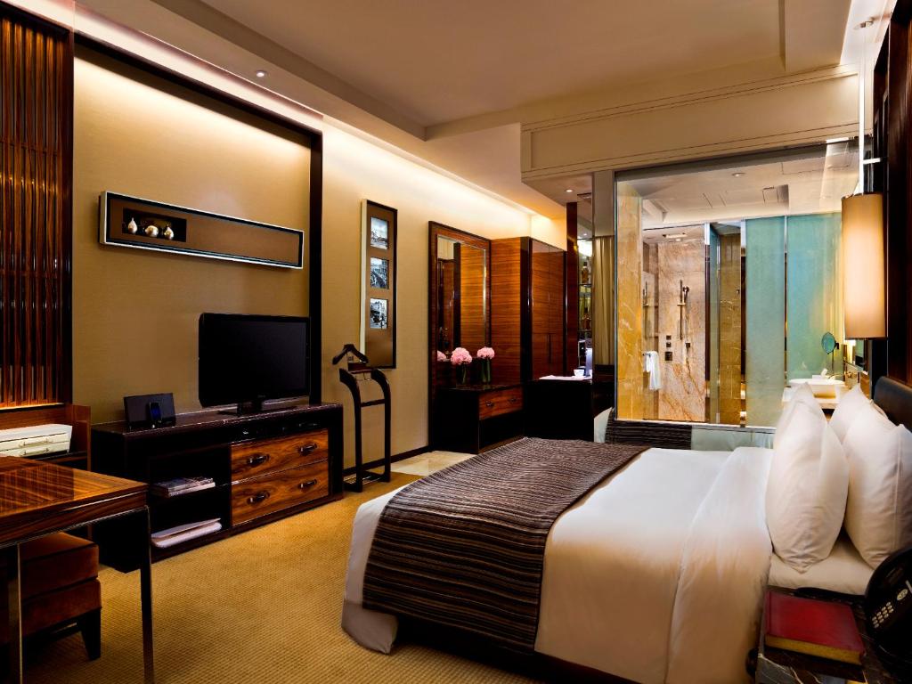 a hotel room with a bed and a television at The Fullerton Bay Hotel Singapore in Singapore