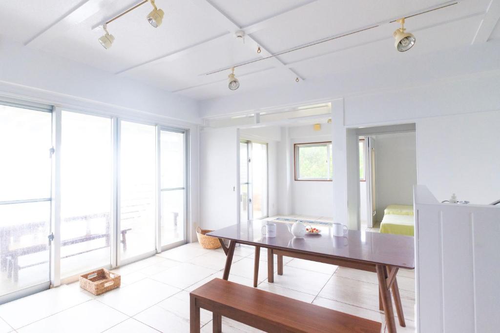 石垣島的住宿－amber moon，一间带桌子和大窗户的用餐室