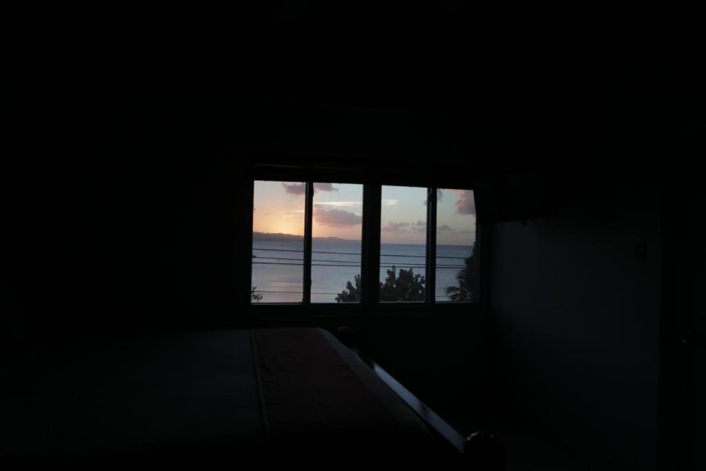a dark room with a window looking out at the ocean at Altamont West Hotel in Montego Bay