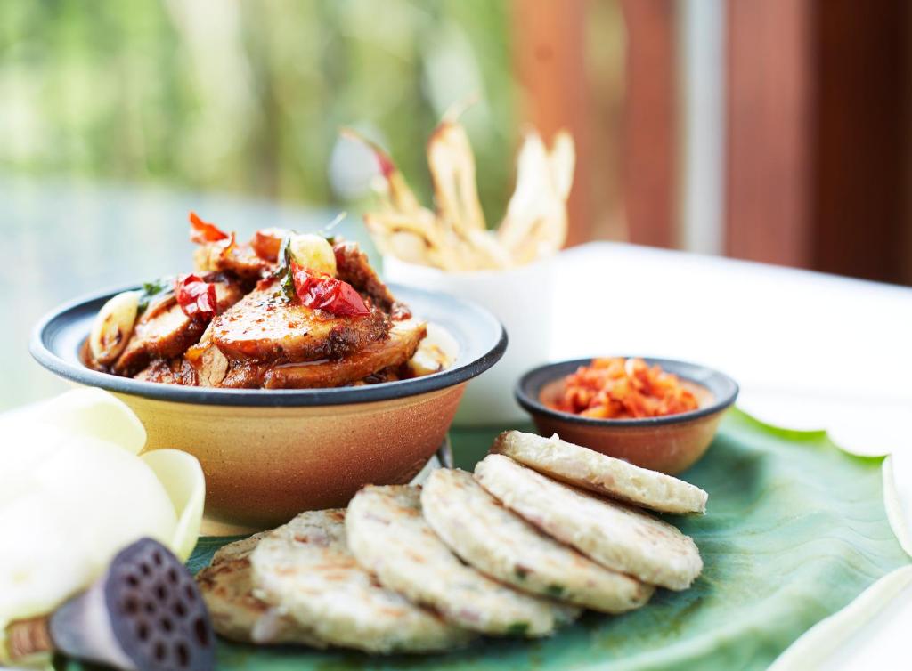 a table with a bowl of food and some snacks at Jetwing Vil Uyana, A Luxury Reserve in Sigiriya