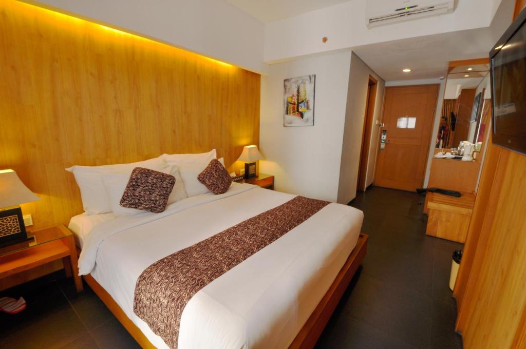 1 dormitorio con 1 cama grande en una habitación de hotel en Ping Hotel Seminyak Bali, en Seminyak