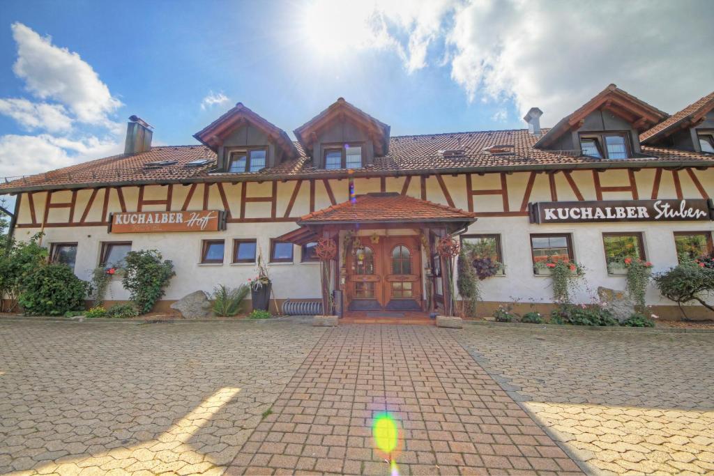 ein großes Gebäude mit einer Holztür auf einer Straße in der Unterkunft Hotel Kuchalber Hof in Donzdorf