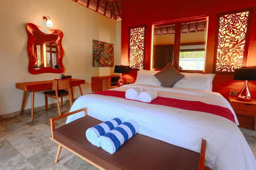 a bedroom with a large bed with two towels on it at A Villa Gili Air in Gili Islands