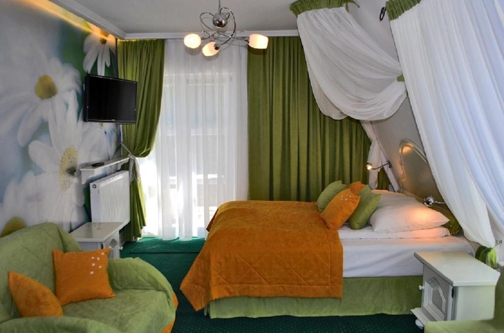 ナウェンチュフにあるKomfortowe Pokoje Samoniówkaのベッドルーム(ベッド1台、ソファ、テレビ付)