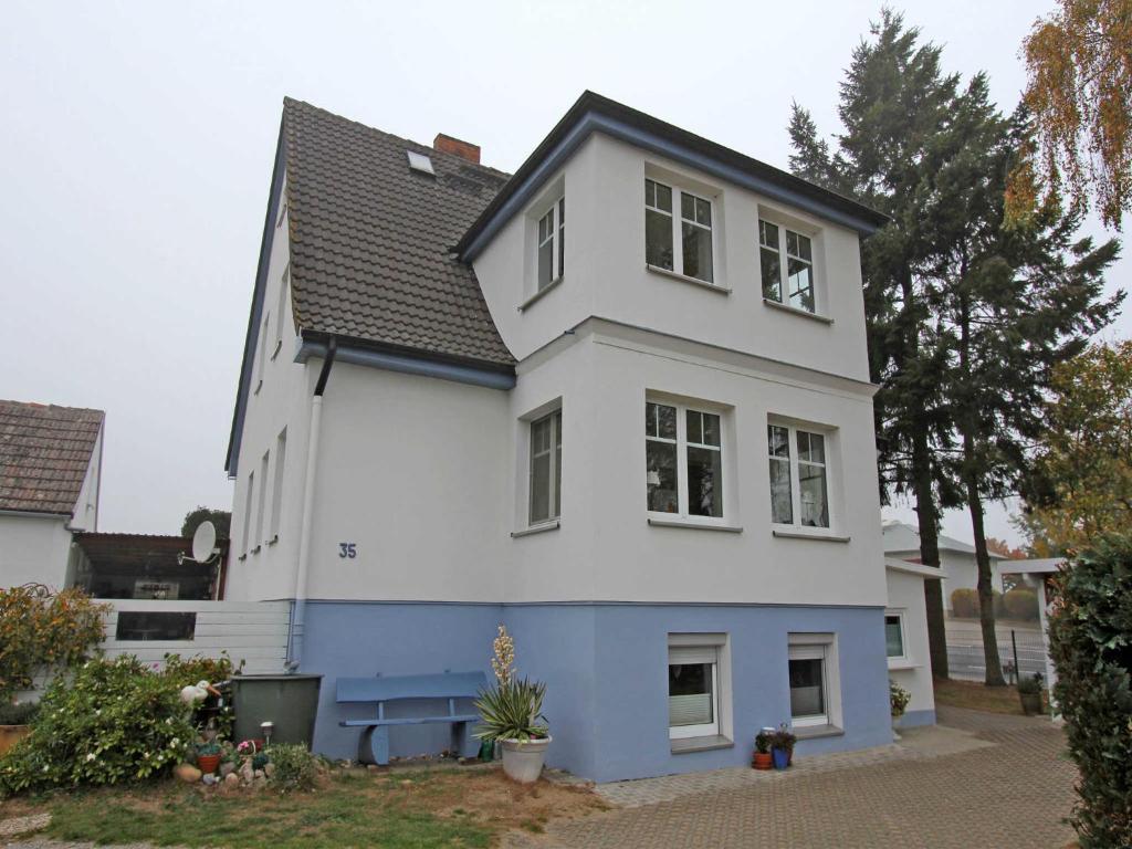 ヘリングスドルフにあるFerienappartements Heringsdorf USEの黒屋根白青住宅