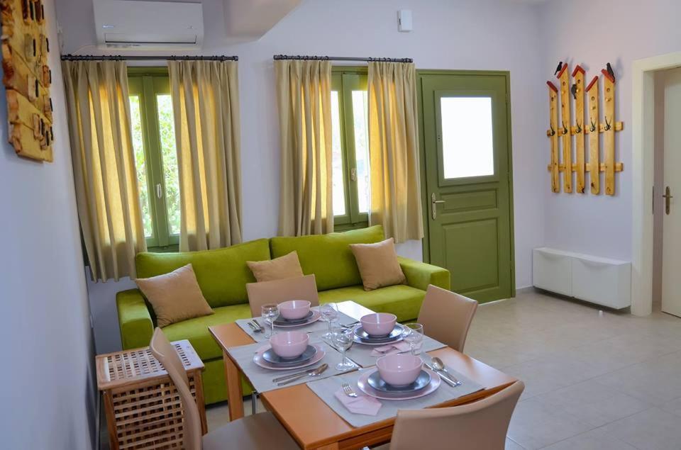 a living room with a green couch and a table at Vanna's Apartments in Leonidion