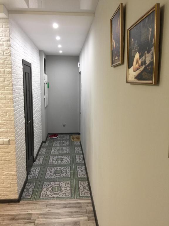 a hallway with a tile floor and two pictures on the wall at Двухкімнатна студія in Chernihiv