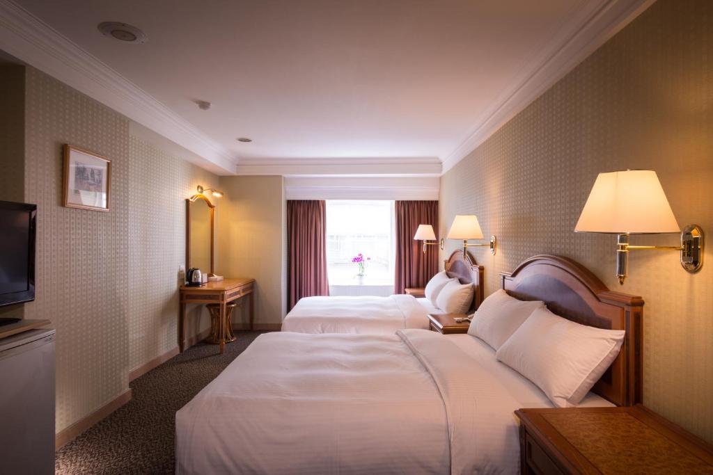台北的住宿－洛碁大飯店花華分館，酒店客房设有两张床和窗户。