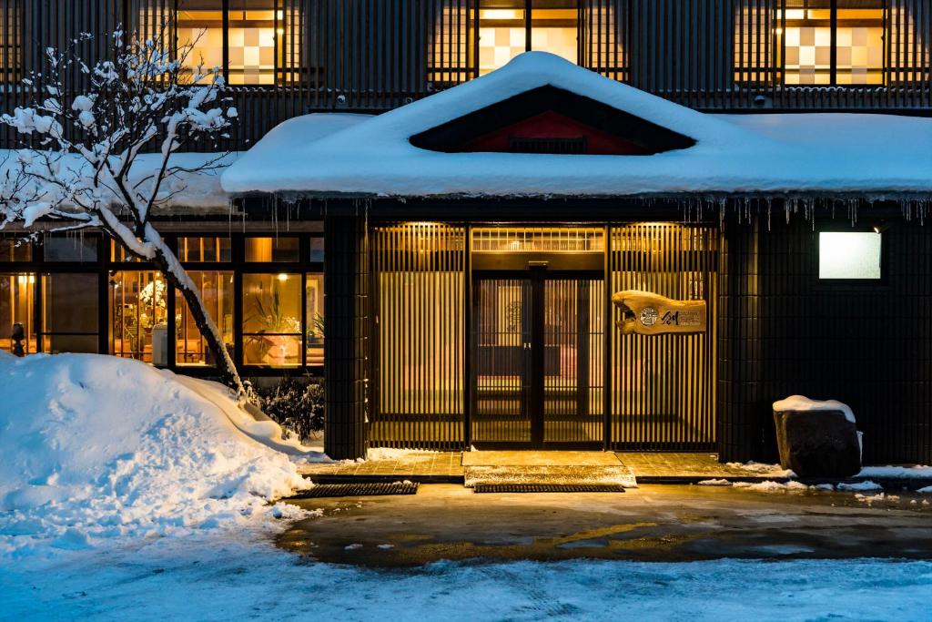 a building with snow on the front of it at Meitoya So in Zao Onsen