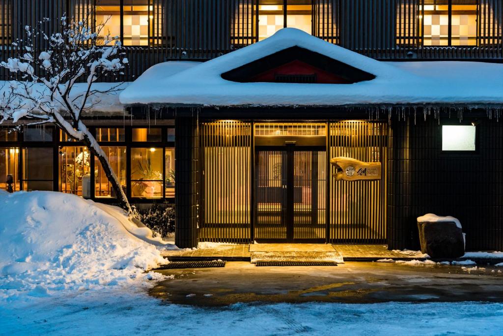 un edificio con nieve en la parte delantera en Meitoya So en Zao Onsen