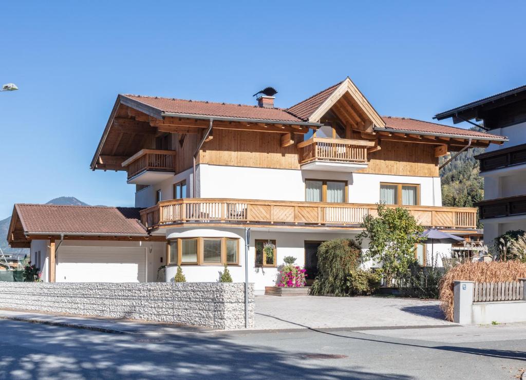 a large white house with a wooden roof at Apartpension Oberhauser in Kaprun