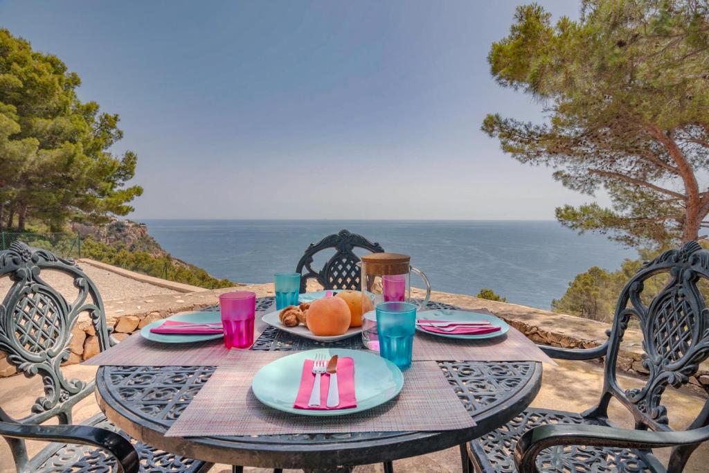una mesa con un plato de comida y vistas al océano en Villa Mirador, Javea, en Balcón del Mar