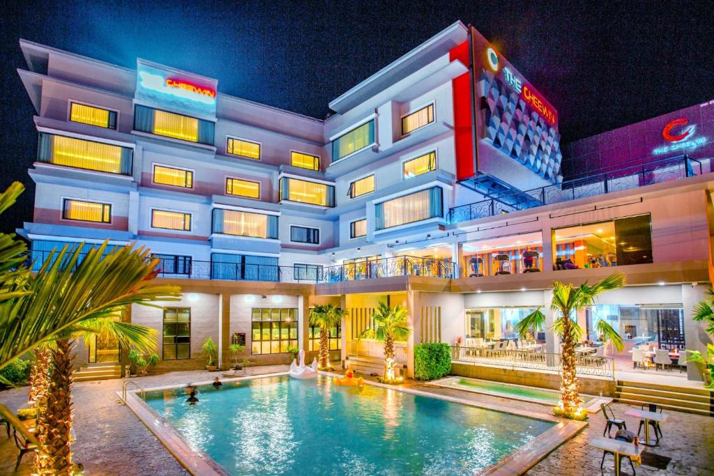 un hotel con piscina di fronte a un edificio di The Cheewin Hotel And Convention a Chum Phae