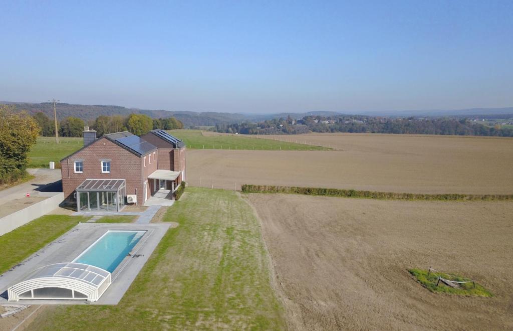 an aerial view of a house with a swimming pool and a field at Vue d'en Haut in Durbuy