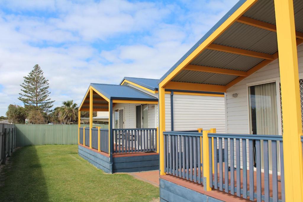 uma casa com um alpendre frontal azul e amarelo em Belair Gardens Caravan Park em Geraldton